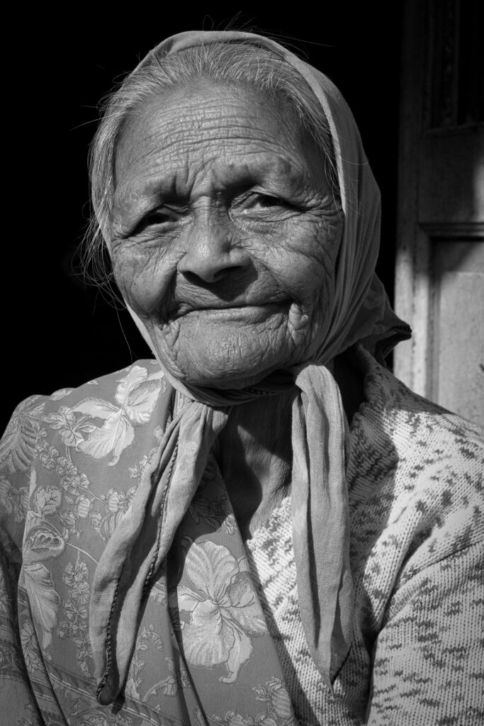 A poignant black and white portrait of a senior woman wearing a headscarf, exuding wisdom and experience.